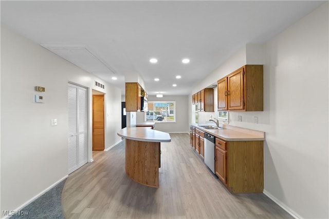 kitchen with light countertops, brown cabinets, dishwasher, a sink, and visible vents