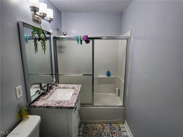 full bathroom featuring tile patterned flooring, toilet, vanity, baseboards, and bath / shower combo with glass door