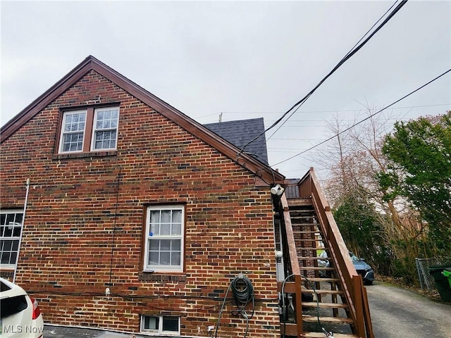 view of property exterior with stairs and brick siding