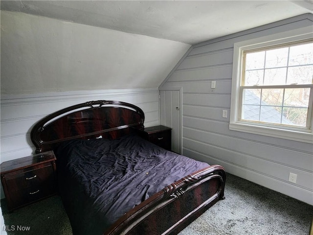 bedroom with a decorative wall, carpet flooring, and lofted ceiling