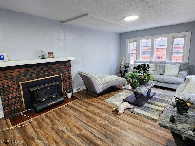 living room with a textured ceiling, wood finished floors, and baseboards