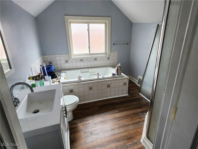 full bath with wood finished floors, vaulted ceiling, a bath, vanity, and visible vents