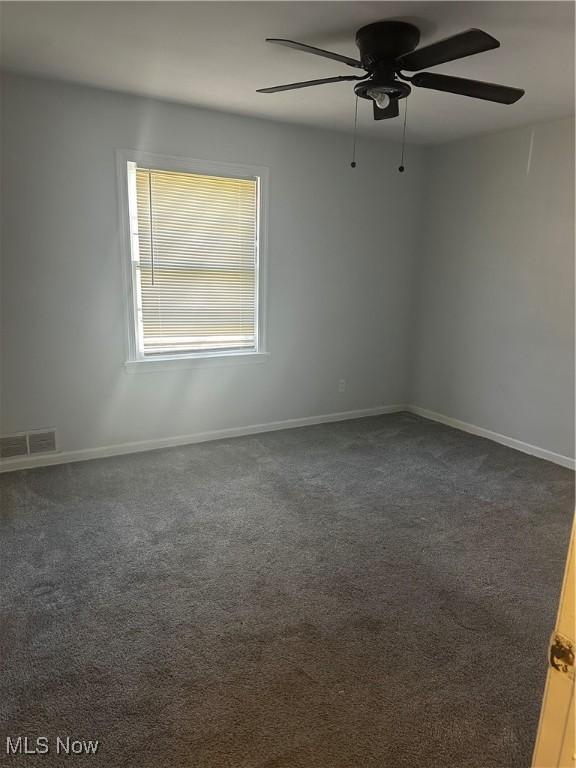 1765 E 238th St, Euclid, OH 44117 - unfurnished room with a ceiling fan, visible vents, dark carpet, and baseboards