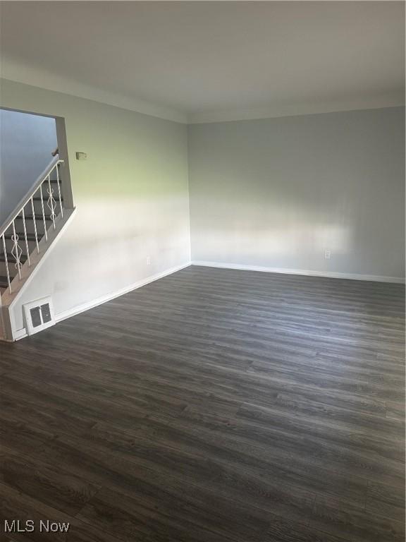 1765 E 238th St, Euclid, OH 44117 - empty room featuring baseboards, visible vents, stairs, and dark wood-type flooring