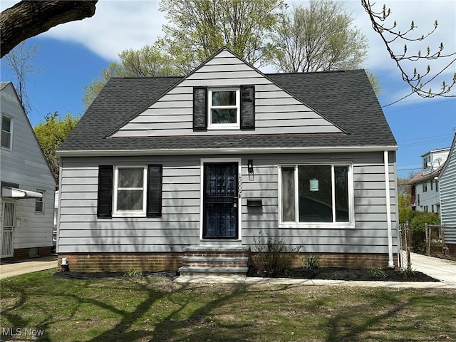 bungalow-style house with a front yard and roof with shingles