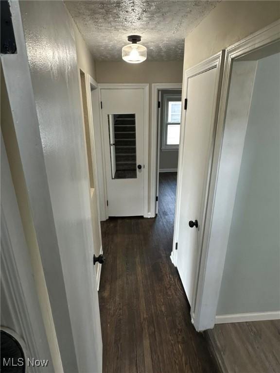hallway with dark wood-style floors and baseboards
