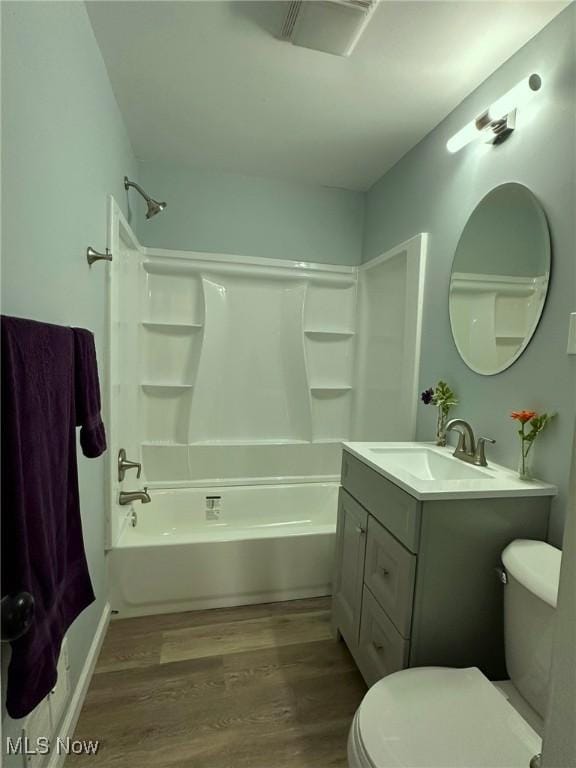 bathroom featuring wood finished floors, toilet, washtub / shower combination, and vanity