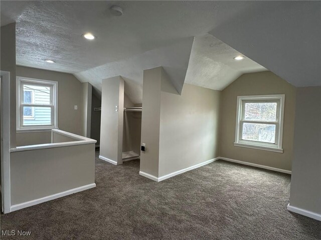 bonus room featuring baseboards, recessed lighting, dark carpet, and vaulted ceiling