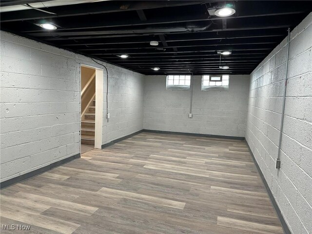 basement featuring stairway and wood finished floors