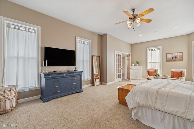 bedroom featuring ceiling fan, light carpet, and baseboards