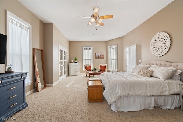 bedroom with light colored carpet, a ceiling fan, and baseboards