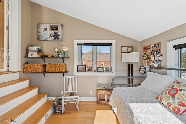bedroom with lofted ceiling, wood finished floors, and baseboards
