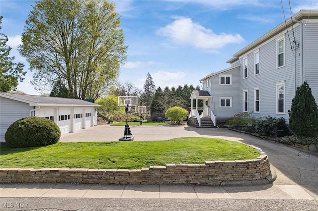 exterior space with a detached garage and a yard