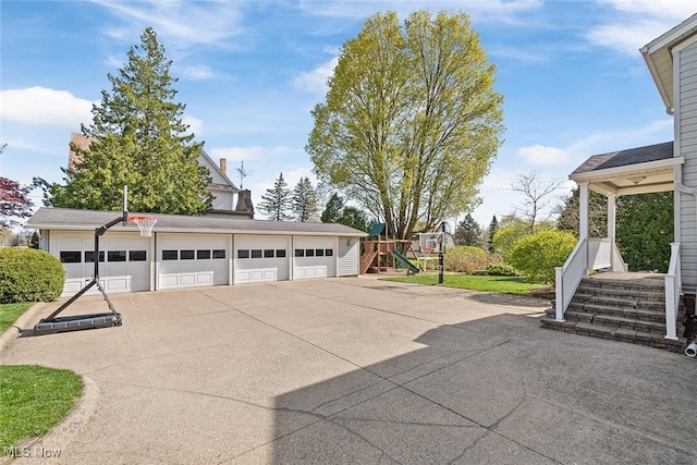 exterior space featuring a garage, an outbuilding, and a playground