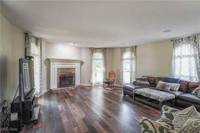 living area with a fireplace, baseboards, and wood-type flooring