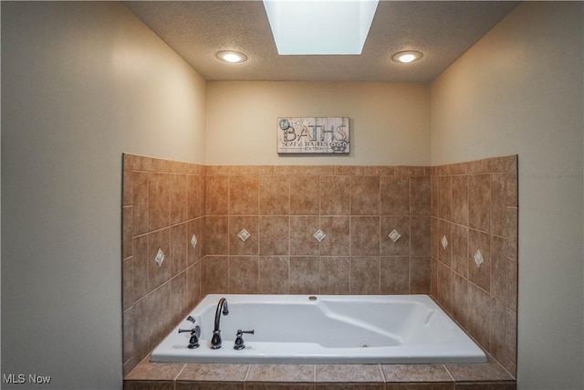 full bath featuring a textured ceiling and a jetted tub
