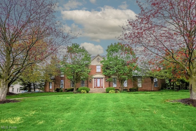 view of front of house featuring a front lawn and brick siding