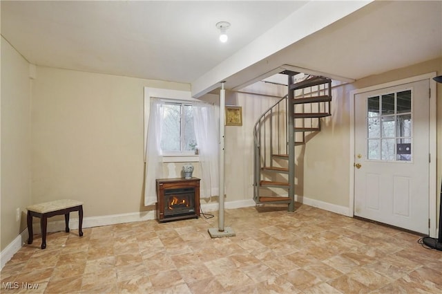 below grade area featuring stone finish flooring, baseboards, and stairs