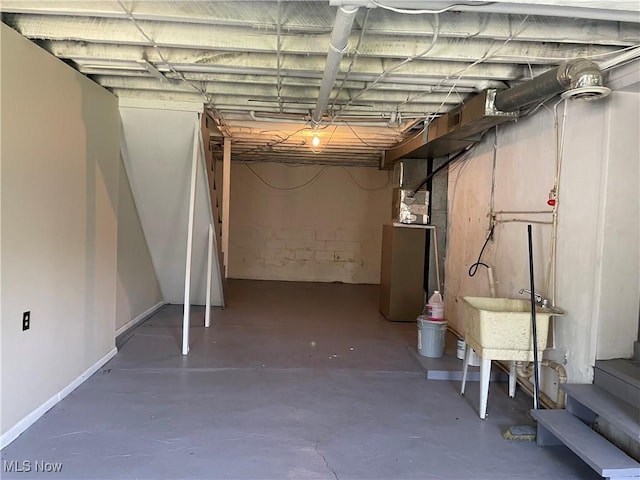 unfinished below grade area featuring baseboards and stairs