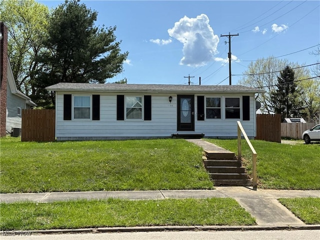 ranch-style house featuring cooling unit, a front yard, and fence