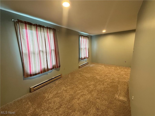 carpeted spare room with recessed lighting, baseboard heating, and a baseboard radiator