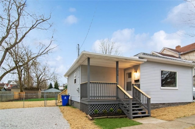 bungalow-style house featuring a porch, crawl space, and fence