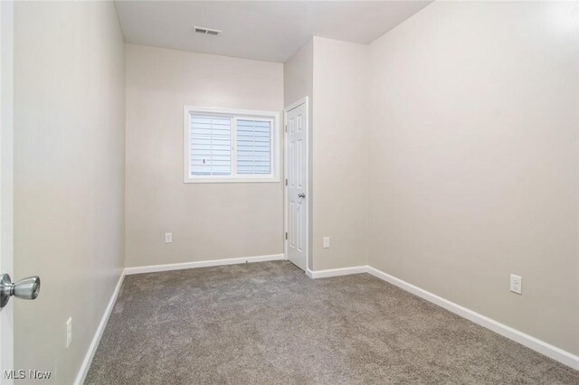 carpeted empty room with visible vents and baseboards