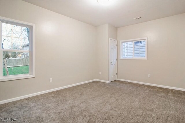 carpeted spare room with baseboards and visible vents