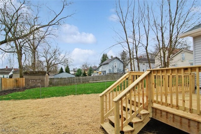 wooden deck with a lawn, a residential view, and a fenced backyard