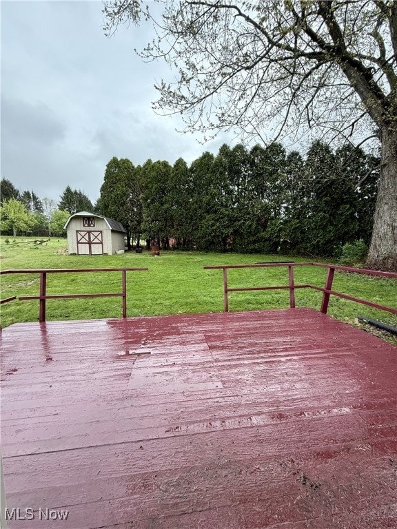 wooden deck with a yard, a shed, and an outbuilding