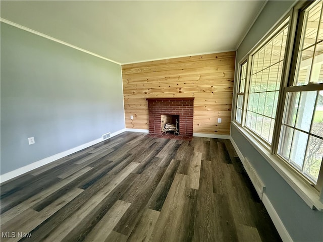 unfurnished living room featuring dark wood-type flooring, plenty of natural light, and baseboards