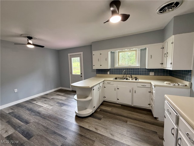kitchen with light countertops, a sink, white cabinetry, visible vents, and a ceiling fan