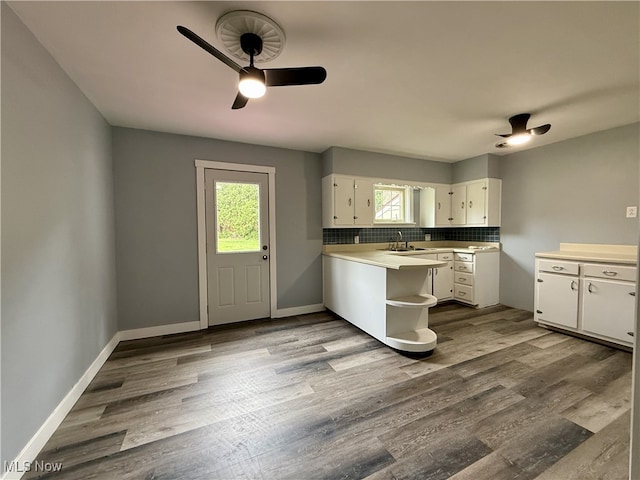 kitchen featuring white cabinets, ceiling fan, light countertops, dark wood-style floors, and backsplash
