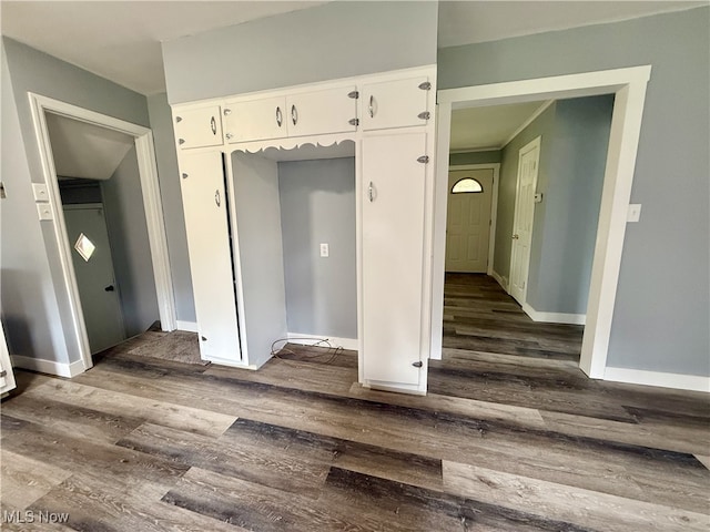 interior space featuring dark wood-type flooring and baseboards