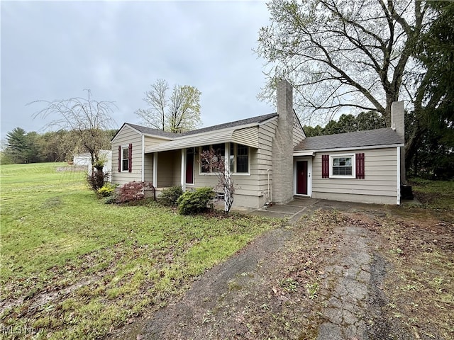 single story home with a chimney and a front yard