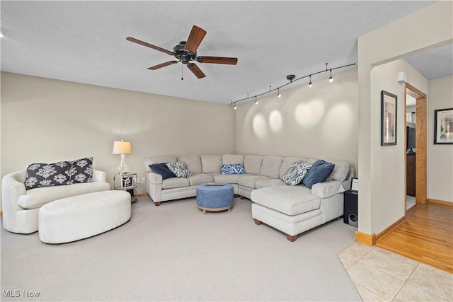 living area with light tile patterned flooring, a ceiling fan, rail lighting, and light colored carpet