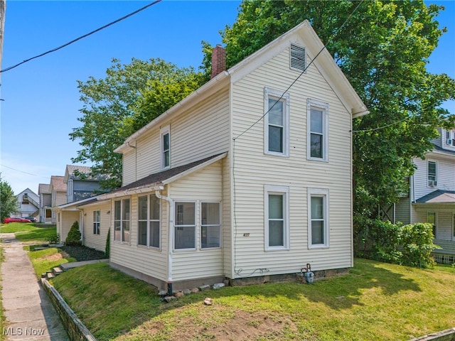 view of home's exterior featuring a yard and a chimney