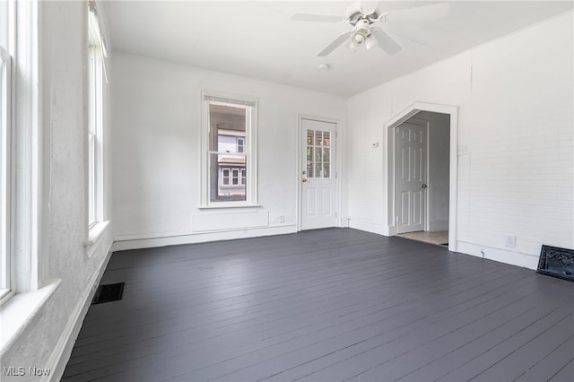 interior space with a ceiling fan, visible vents, wood finished floors, and baseboards