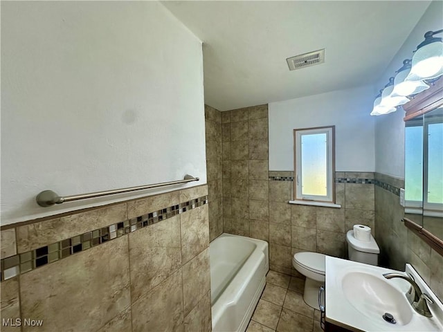 7003 Claybourne Ave, Boardman, OH 44512 - bathroom with tile patterned flooring, a tub, tile walls, toilet, and visible vents