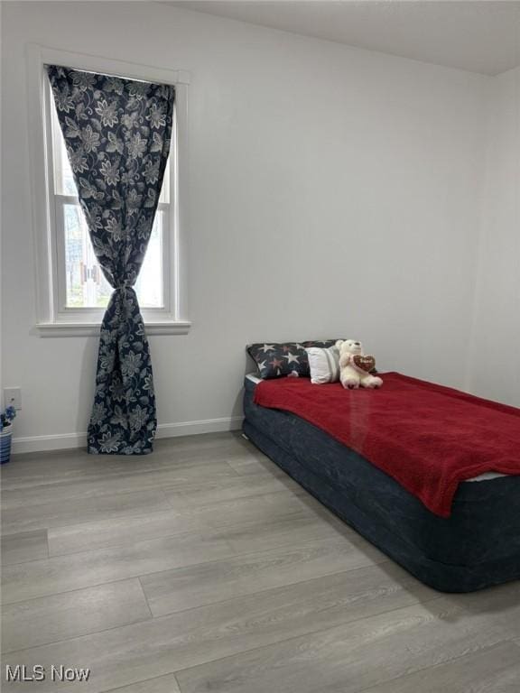 bedroom featuring baseboards and wood finished floors