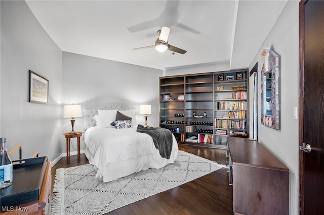 bedroom with ceiling fan, wood finished floors, and baseboards