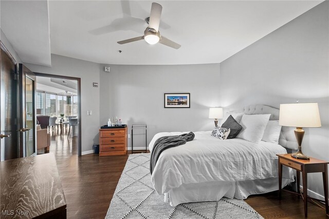 bedroom with wood finished floors, a ceiling fan, and baseboards