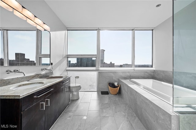 full bath with a sink, a wealth of natural light, and a city view