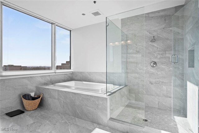 full bathroom with visible vents, a bath, and a stall shower