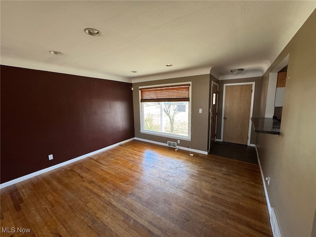 interior space featuring baseboards, visible vents, and wood finished floors