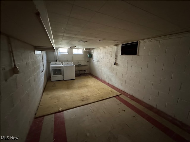basement with washer and clothes dryer and a sink