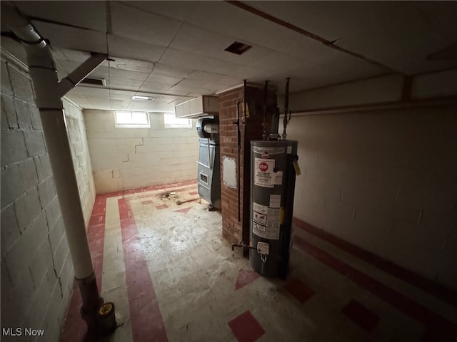 basement featuring gas water heater and concrete block wall
