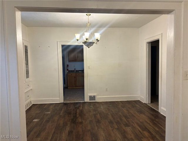 12608 Corlett Ave, Cleveland, OH 44105 - unfurnished dining area featuring dark wood-style flooring, a notable chandelier, baseboards, and visible vents