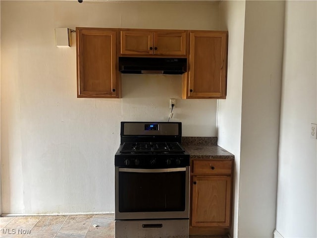 12608 Corlett Ave, Cleveland, OH 44105 - kitchen with gas range, dark countertops, brown cabinets, and under cabinet range hood