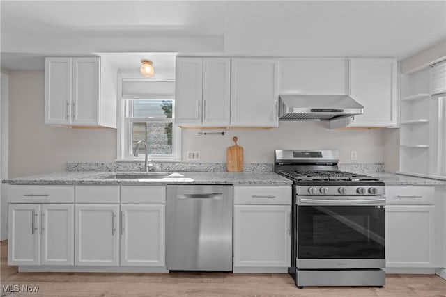 kitchen featuring a sink, stainless steel appliances, white cabinets, and wall chimney exhaust hood